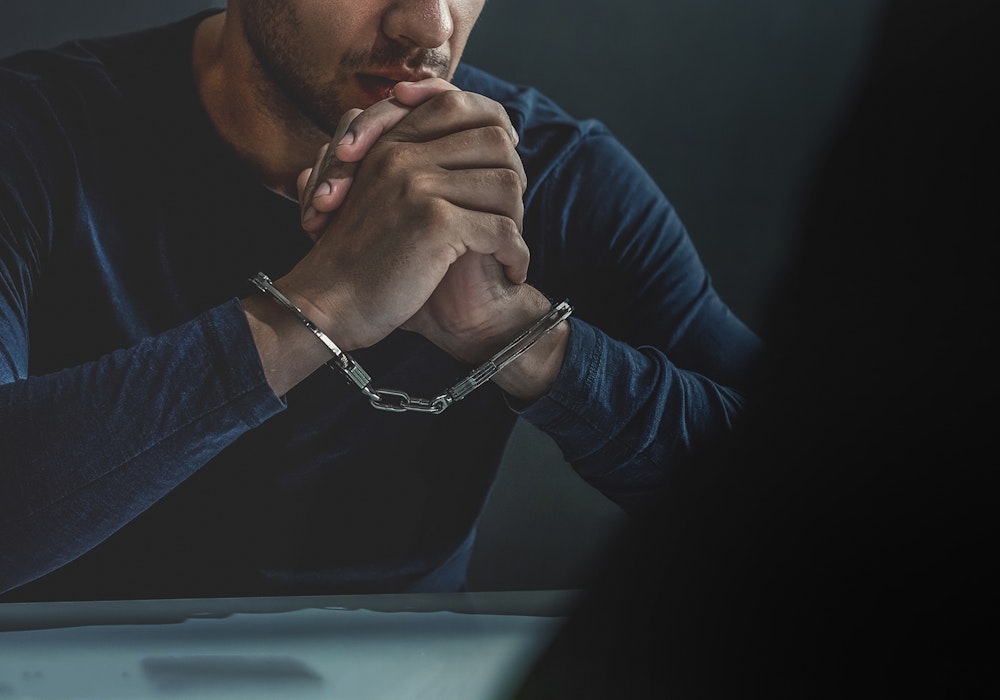 Man in handcuffs being interrogated